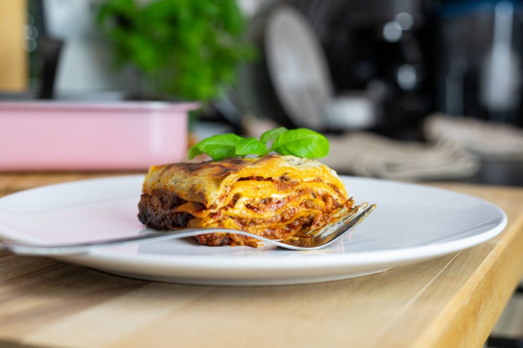 Gros plan sur une lasagne savoureuse garnie de basilic, mettant en valeur la cuisine italienne traditionnelle.