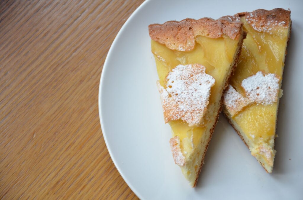 Délicieuses tranches de tarte au citron maison sur une assiette blanche propre, parfaites pour les amateurs de dessert.