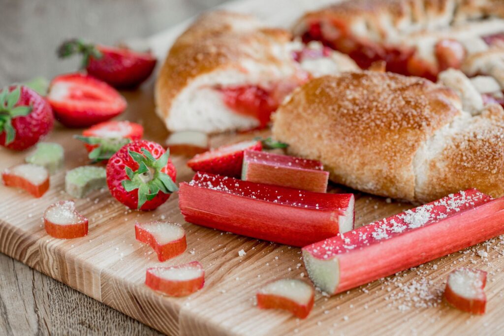 Gros plan sur une pâtisserie fraîche aux fraises et à la rhubarbe sur une planche en bois.