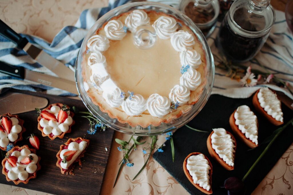 Une vue de dessus de pâtisseries maison assorties avec de la crème fouettée et des garnitures de fraises.