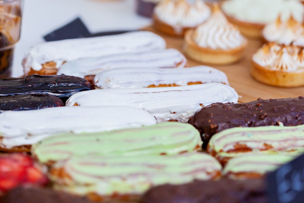 Vue rapprochée de divers éclairs et pâtisseries parfumés, parfaits pour des thèmes de dessert et de boulangerie.
