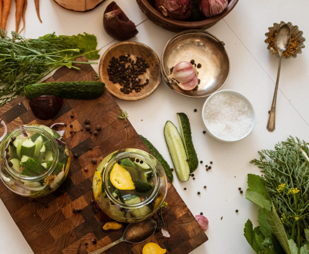 Vue aérienne d'une table de cuisine avec des légumes frais et préparation de cornichons.