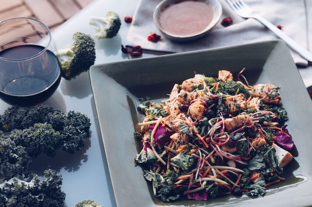 Délicieuse salade de poulet grillé avec du chou frisé, du brocoli et du vin sur une table élégante.