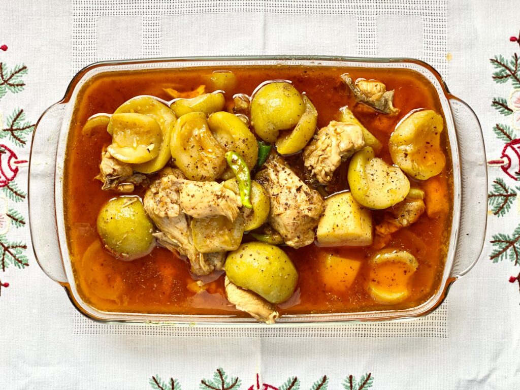 Vue du dessus d'un copieux ragoût de poulet et de légumes dans un plat en verre.