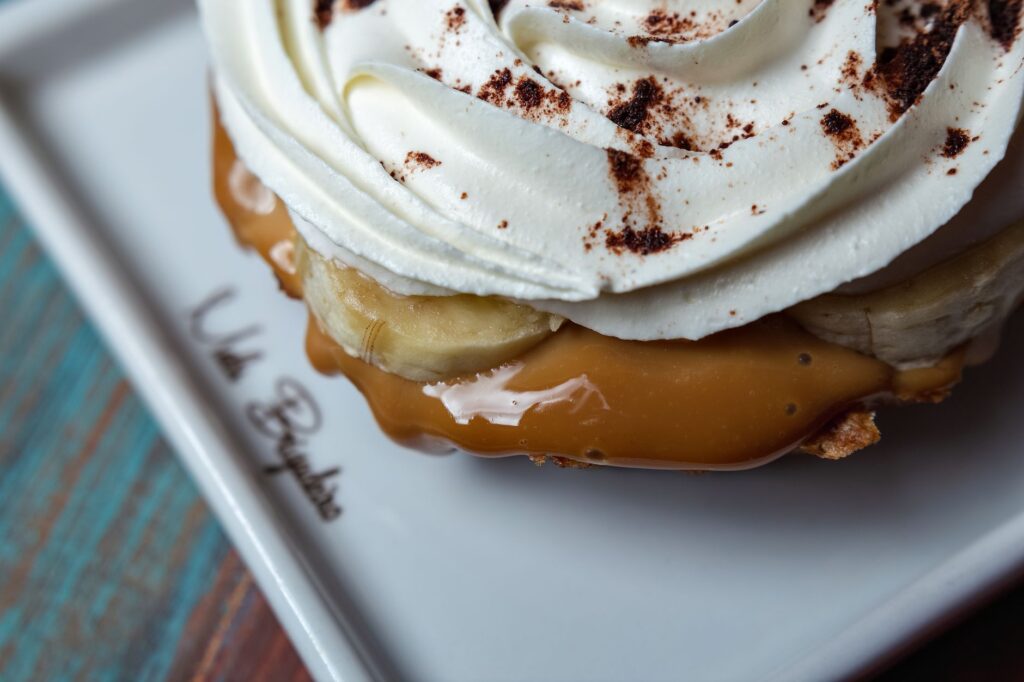Vue rapprochée d'une tarte banoffee crémeuse avec caramel, bananes et crème chantilly.