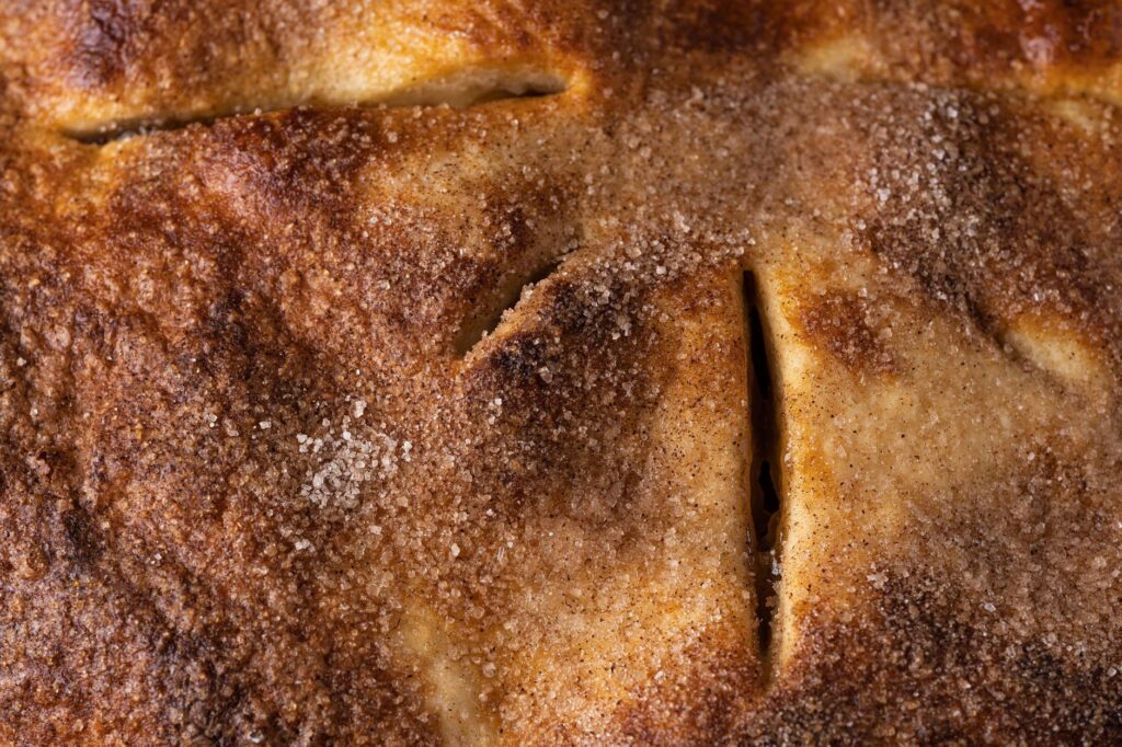 Un gros plan détaillé d'une croûte de tarte à la cannelle fraîchement cuite.