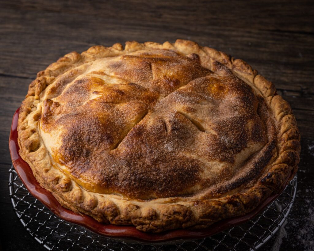 Une délicieuse tarte dorée en train de refroidir sur une grille, prête à être dégustée.