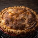 Une délicieuse tarte dorée en train de refroidir sur une grille, prête à être dégustée.