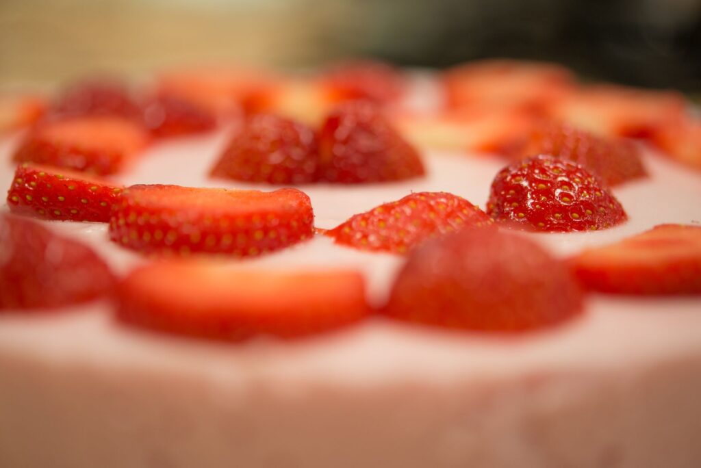 Prise de vue macro d'un délicieux dessert à la crème garni de fraises, parfait pour une douce indulgence.