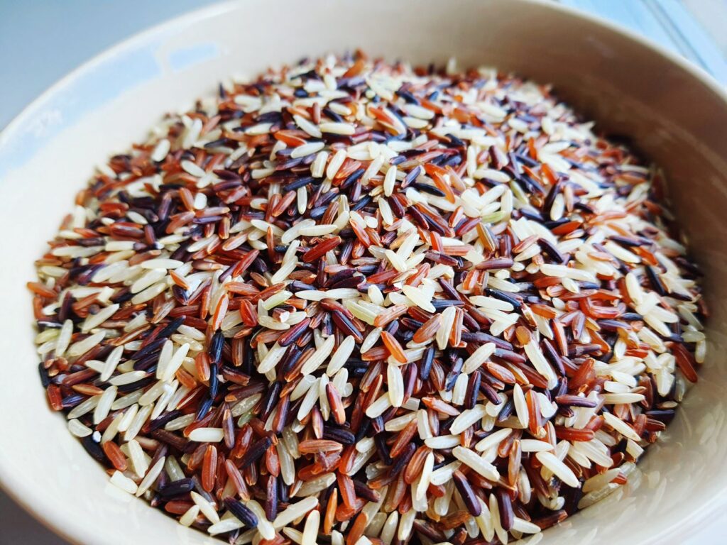 Gros plan d'un mélange de riz sauvage et de riz blanc dans un bol, mettant en valeur la texture et la couleur.