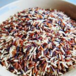Gros plan d'un mélange de riz sauvage et de riz blanc dans un bol, mettant en valeur la texture et la couleur.
