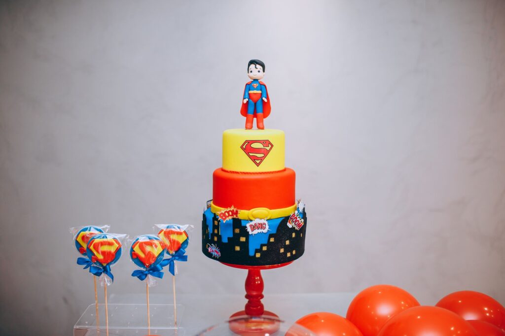 Gâteau Superman vibrant avec des décorations sur le thème des super-héros et des ballons.