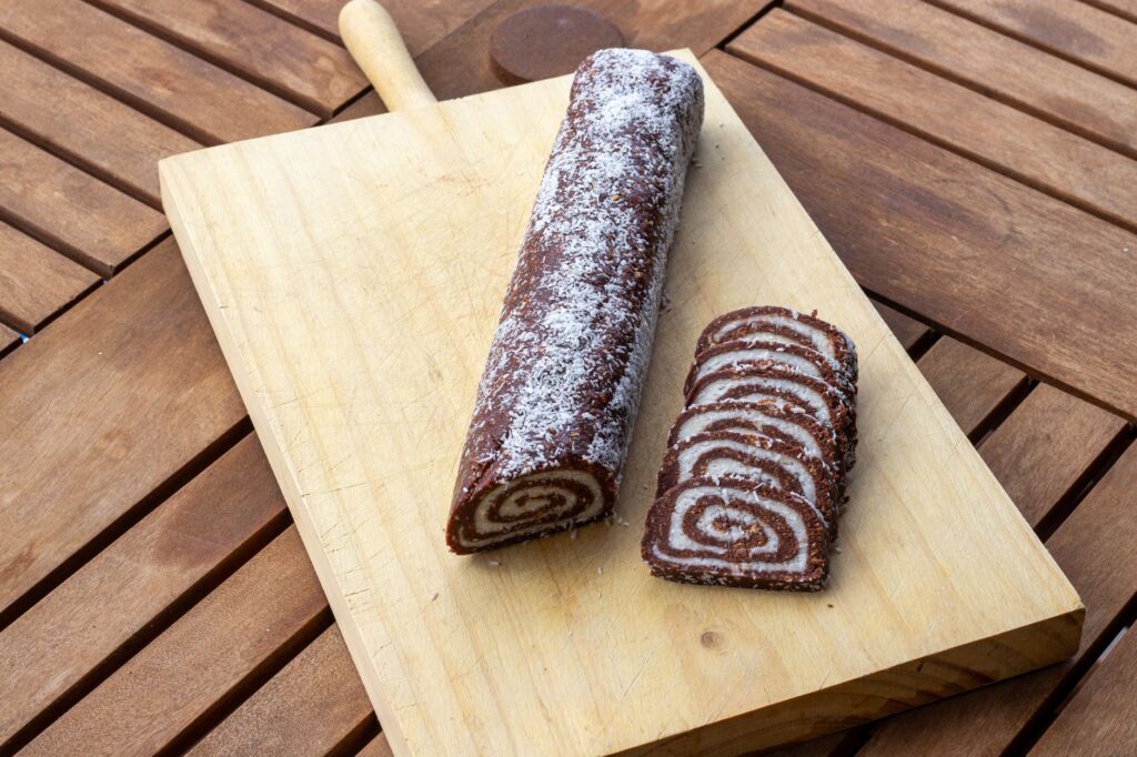 Délicieux roulé suisse au chocolat avec des tranches sur une planche en bois, parfait pour des idées de dessert.
