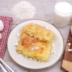 Délicieuse pâtisserie maison servie avec du fromage cottage, des œufs et du lait sur une table en bois.