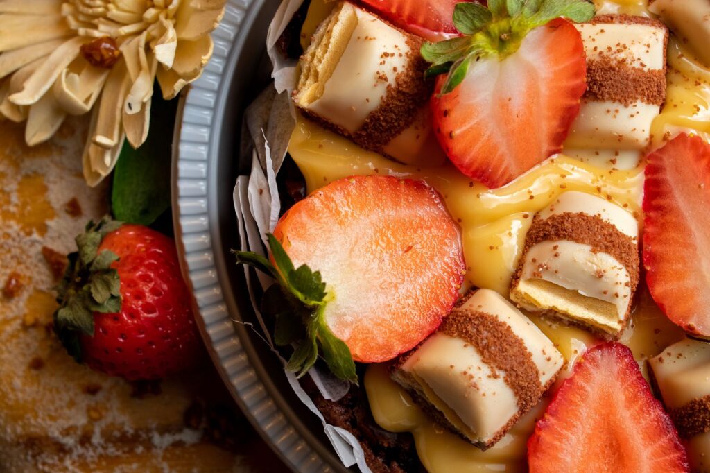 Gros plan d'un dessert aux fraises et à la crème pâtissière avec du chocolat dans un plat à tarte.