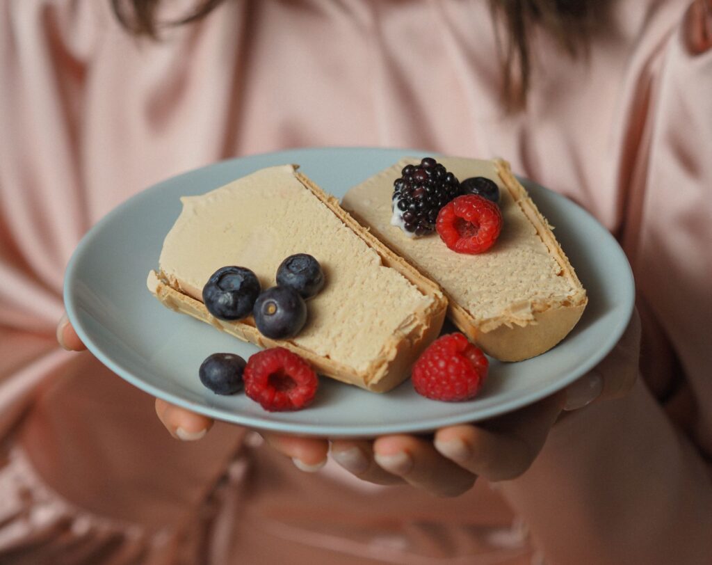 Gros plan d'un dessert crémeux garni de baies fraîches sur une assiette, parfait pour une douce indulgence.
