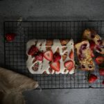 Gâteau délicieux garni de fraises et de glaçage sur une grille de refroidissement.