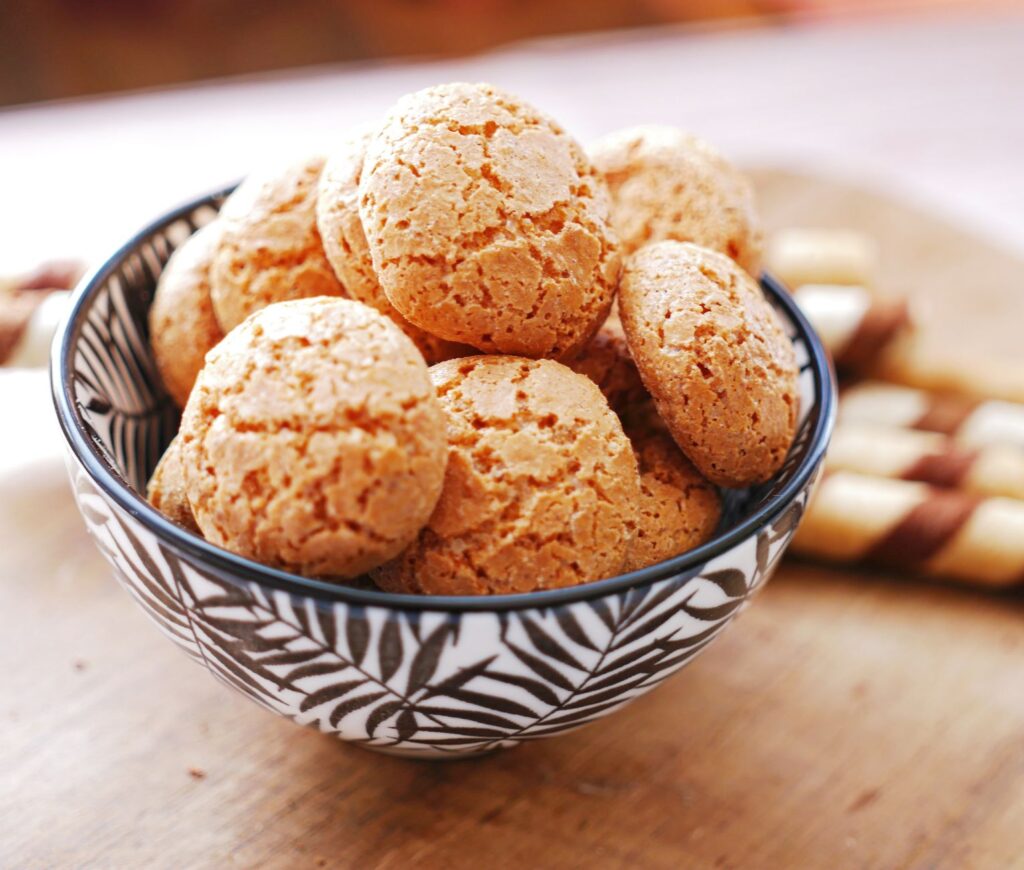 Gros plan sur des biscuits aux amandes dans un bol à motifs, parfait pour les présentations de desserts.