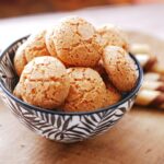 Gros plan sur des biscuits aux amandes dans un bol à motifs, parfait pour les présentations de desserts.