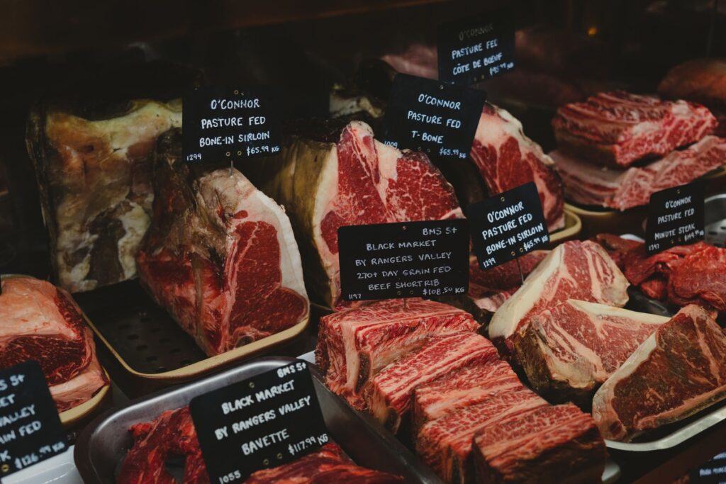 Différentes coupes de bœuf premium avec étiquettes présentées dans un cadre de marché gourmet.