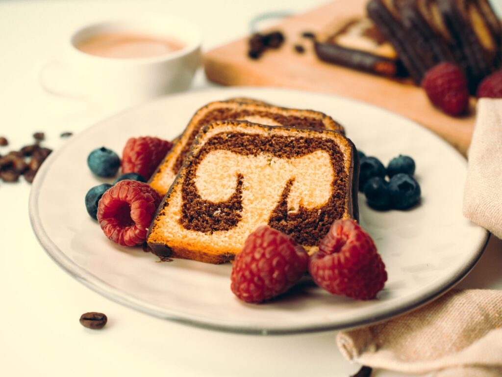 Gros plan sur un gâteau marbré avec des framboises et des myrtilles, cadre parfait pour un dessert.