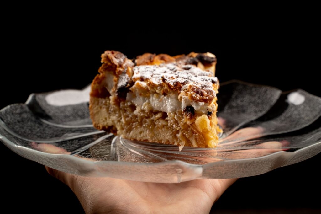 Gros plan d'une part de gâteau aux pommes fraîchement cuite sur une assiette en verre, parfaite pour une présentation de dessert.