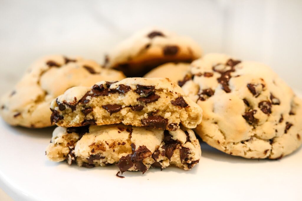 Gros plan de cookies aux pépites de chocolat fraîchement cuits, mettant en valeur leur texture fondante, idéal pour les blogueurs culinaires et les promotions de boulangerie.