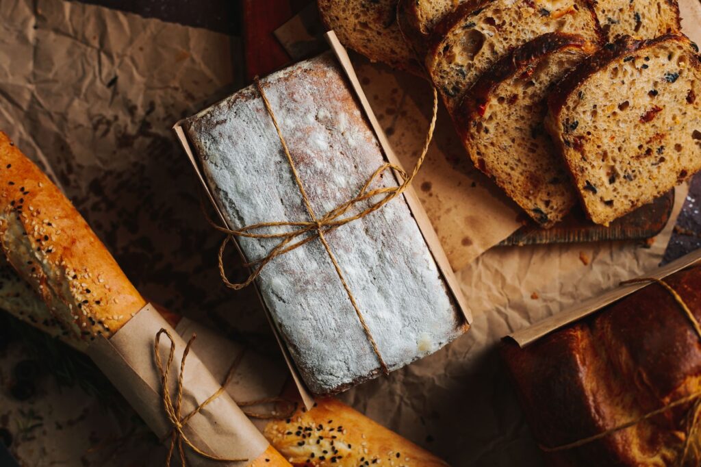 Une vue plongeante de plusieurs pains artisanaux frais, y compris du pain tranché et des baguettes emballées.
