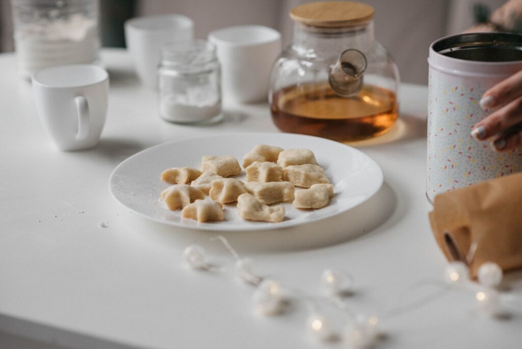 Une scène chaleureuse et accueillante mettant en valeur des biscuits et du thé sur une table blanche minimaliste.