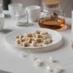 Une scène chaleureuse et accueillante mettant en valeur des biscuits et du thé sur une table blanche minimaliste.