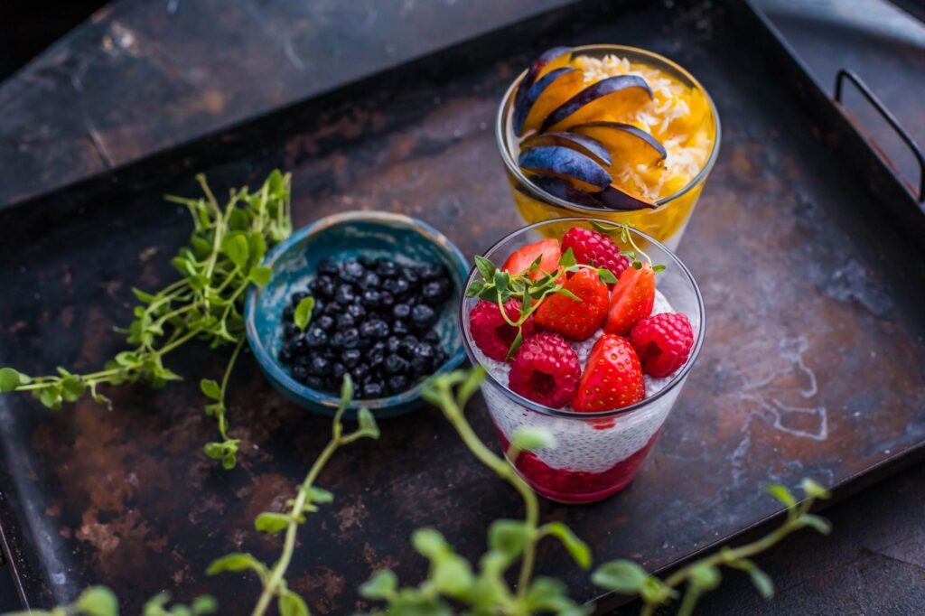 De délicieux parfets de baies et de fruits joliment présentés sur un plateau rustique.
