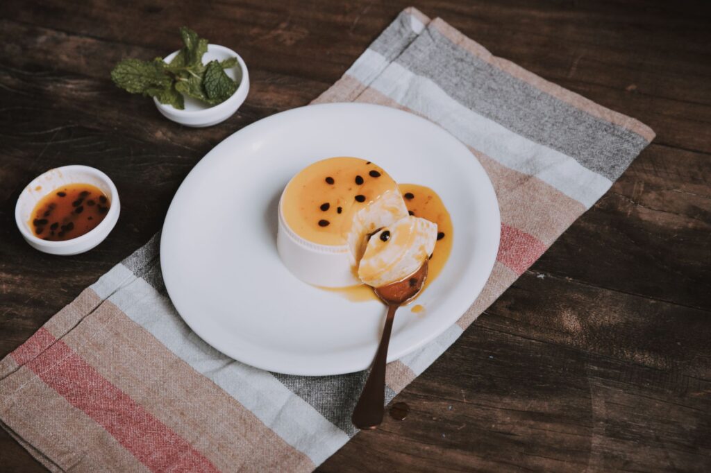 Délicieux flan au fruit de la passion garni de graines et de menthe sur une table rustique, pris à São Paulo, Brésil.