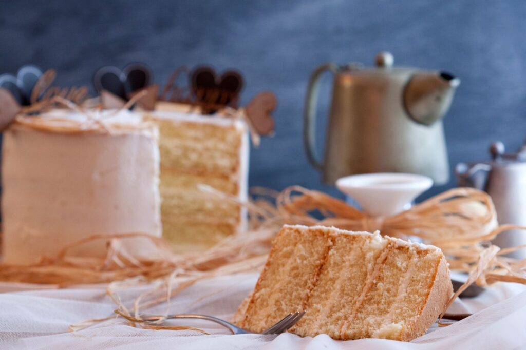 Une délicieuse part de gâteau en couches avec une théière vintage dans un cadre chaleureux, parfait pour se faire plaisir.