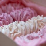 Gros plan sur des meringues roses et blanches dans une boîte, parfaites pour les gourmands.