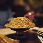 Gros plan de riz frit aux crevettes servi dans un plat sur pied, idéal pour la photographie culinaire.