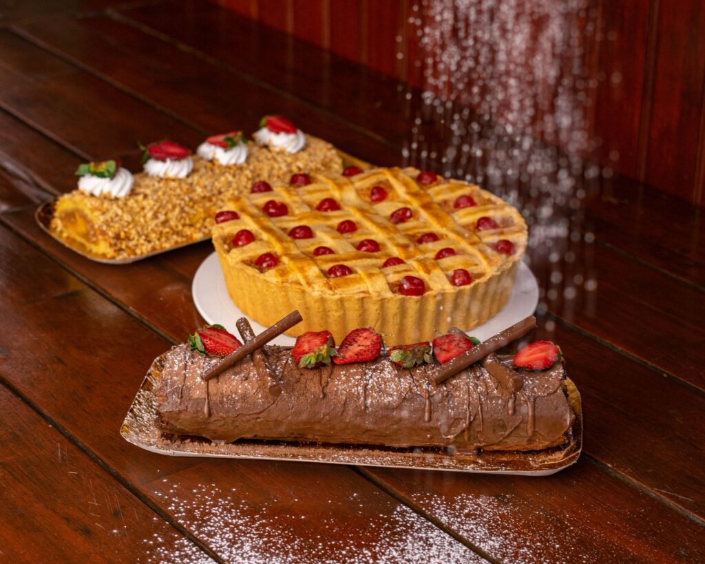 Délicieuse assortiment de tartes et gâteaux garnis de fruits sur une table en bois rustique.