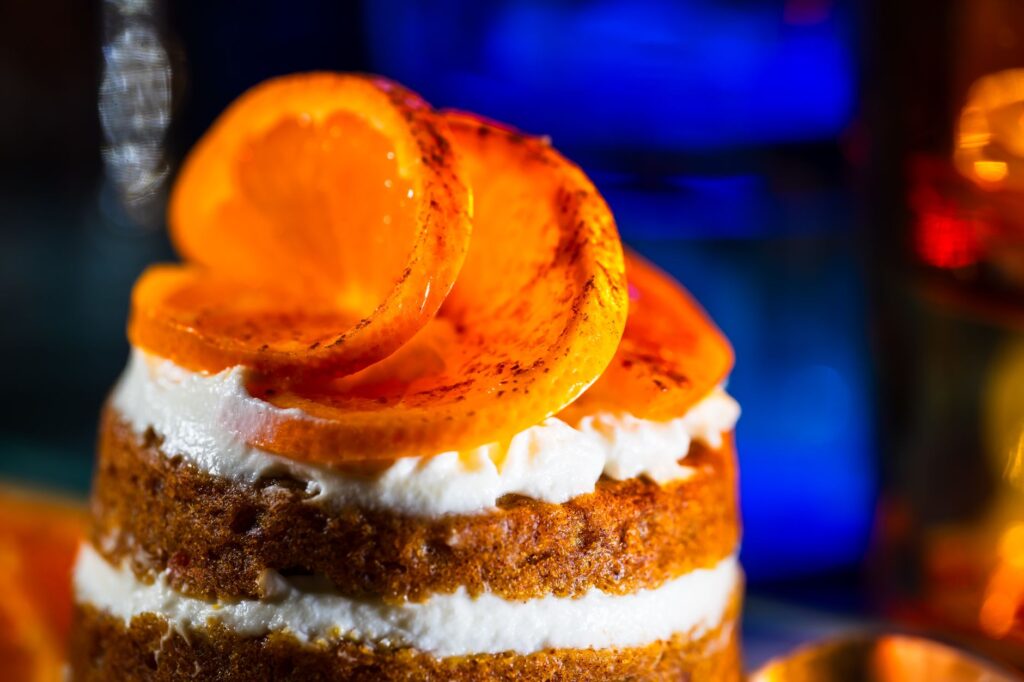 Gros plan sur un dessert délicieux avec des couches crémeuses garnies de tranches d'orange caramélisées.