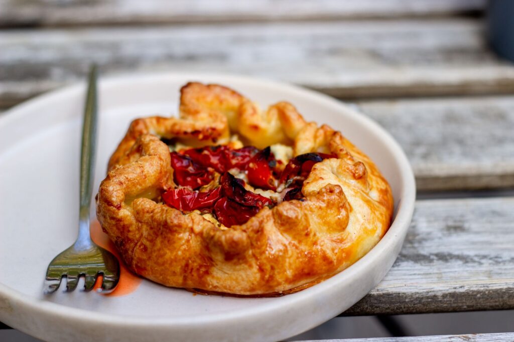 Une délicieuse galette de tomates sur une assiette avec une fourchette, parfaite pour un repas gourmet.