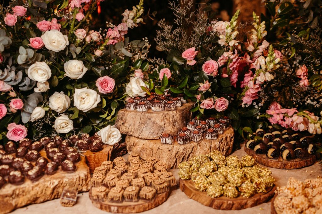Magnifique arrangement de chocolats et de fleurs sur des plateaux en bois, parfait pour des événements élégants.
