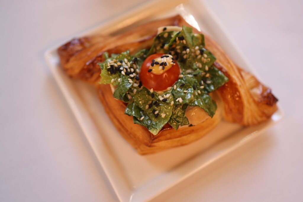 Délicieuse pâtisserie gourmet garnie de salade fraîche et de tomate cerise.