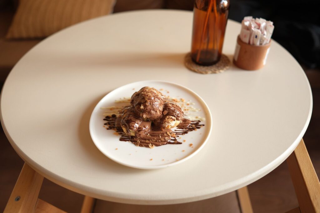 Délicieux profiteroles nappés de sauce au chocolat, cadre de dessert parfait.