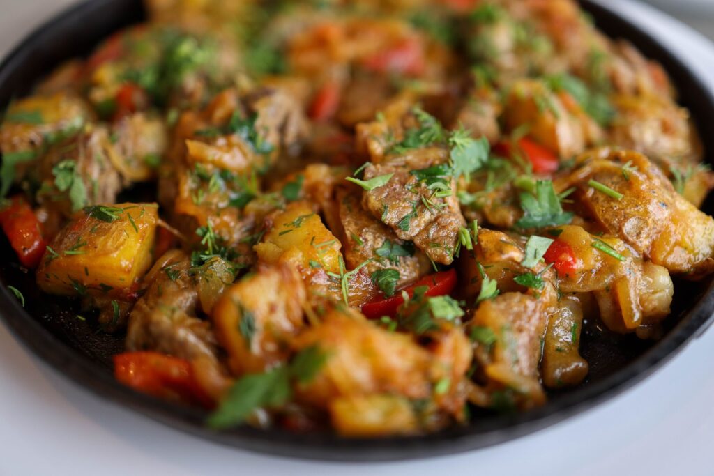 Gros plan de sauté de bœuf savoureux avec des poivrons et des herbes.