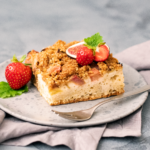 Une part de gâteau fait maison garnie de fraises fraîches et de menthe, parfaite pour un dessert sain.