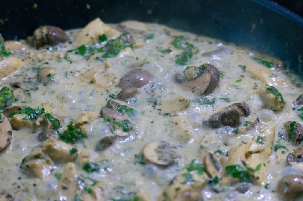 Délicieuse crème de champignons sautés dans une sauce à l'ail savoureuse, garnie d'herbes fraîches.