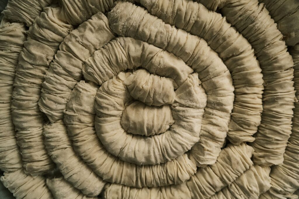 Vue détaillée de pâte roulée formant une forme en spirale, idéale pour des concepts de pâtisserie.
