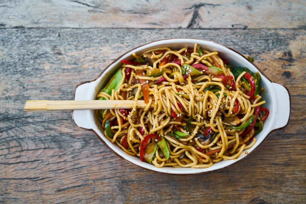 Délicieuses nouilles sautées avec des légumes frais et des graines de sésame, parfaites pour un repas sain.