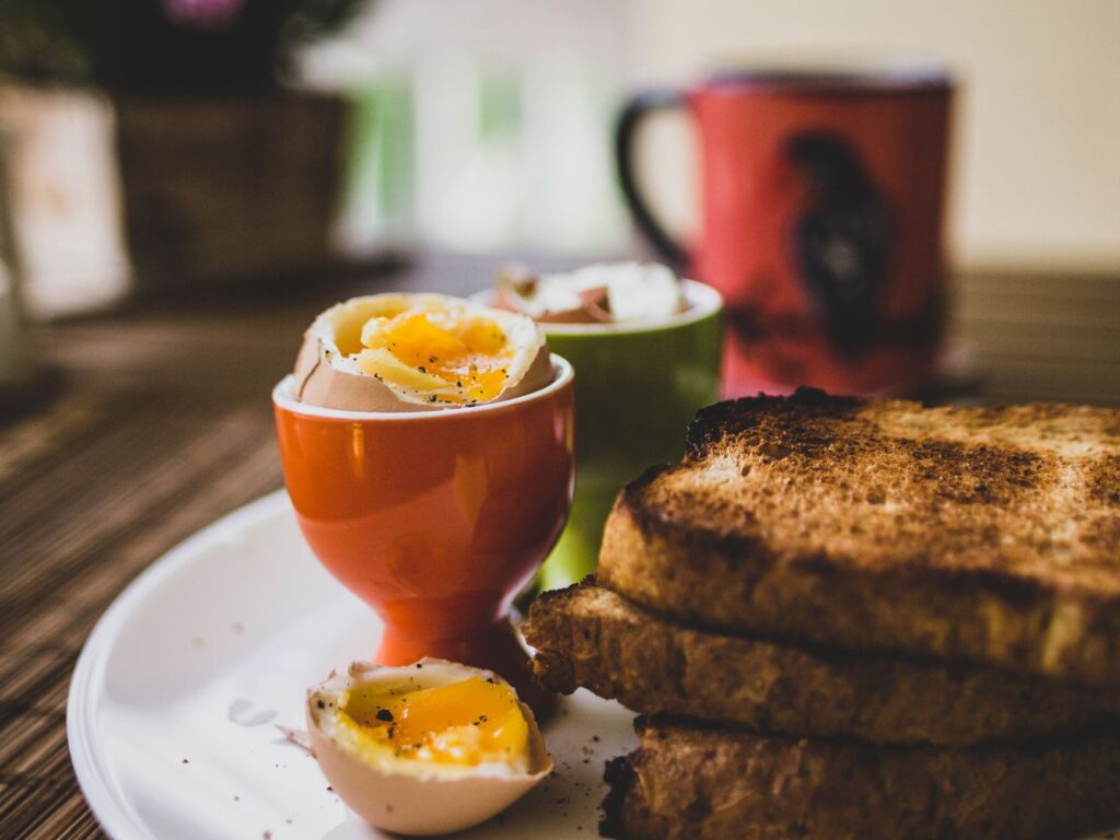 Délicieux petit-déjeuner avec des œufs mollets et du pain grillé, parfait pour bien commencer la journée.