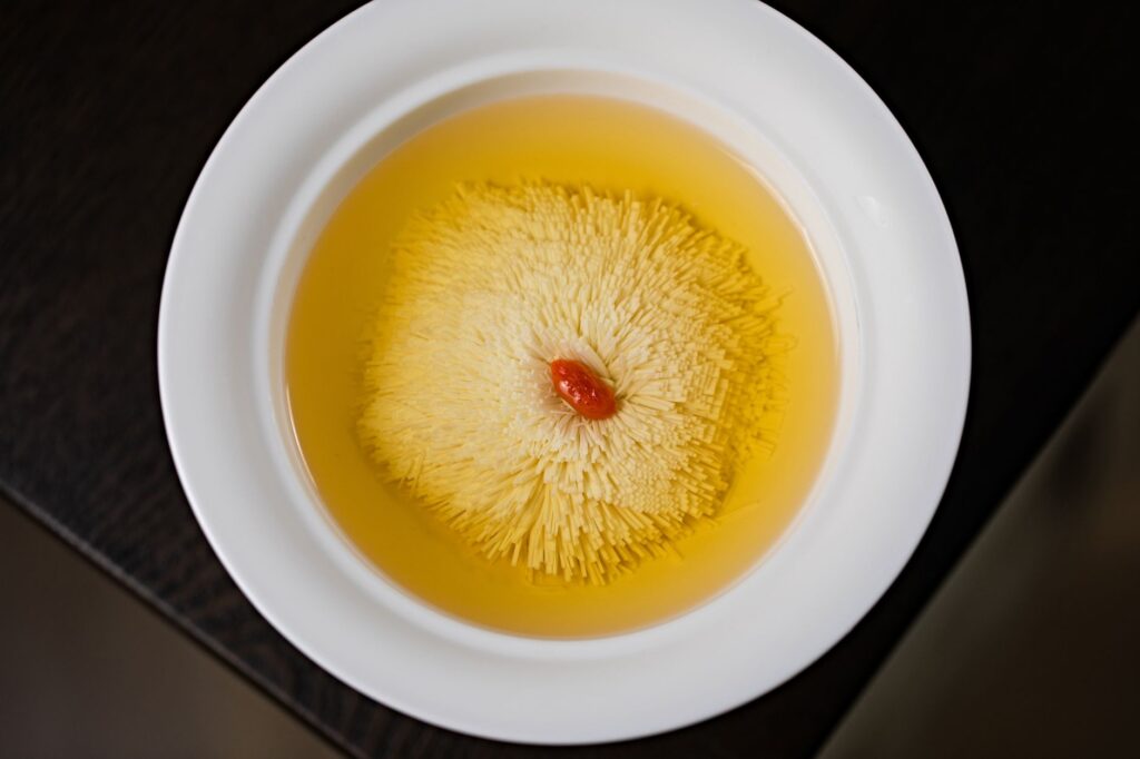 Plan détaillé du thé à la fleur de chrysanthème chinois dans un bol blanc, mettant en avant l'élégance et la délicatesse.