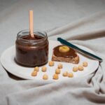 Pâte à tartiner au chocolat et noisettes avec banane sur une tranche de pain, parfait pour le petit-déjeuner.