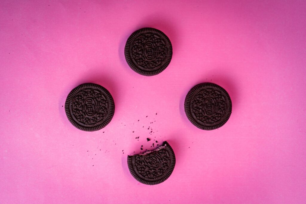 Vue de dessus de biscuits chocolat disposés sur un fond rose vibrant.